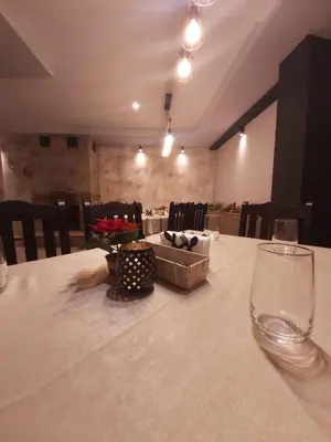 a table with a white table cloth and a glass at Aparthotel Pine Hills Pamporovo in Pamporovo