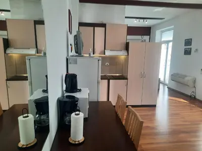 a room with a table and chairs and a kitchen at Studio Cathlyn in Sofia