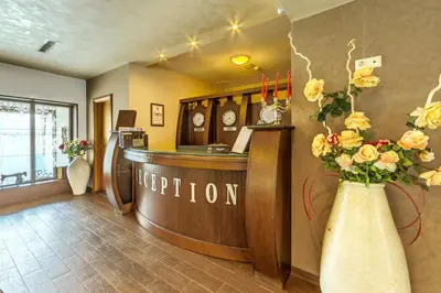 a hotel lobby with a reception desk and flowers in vases at Boutique Hotel L do Rado in Sofia