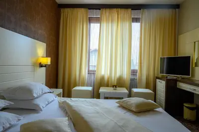 a hotel room with two beds and a flat screen tv at Boutique Hotel L do Rado in Sofia