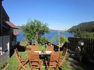 a patio with a table and chairs with a view of the water at Holiday Village Orlino in Sarnitsa