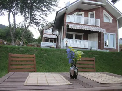 a vase of flowers sitting on a table in front of a house at Holiday Village Orlino in Sarnitsa