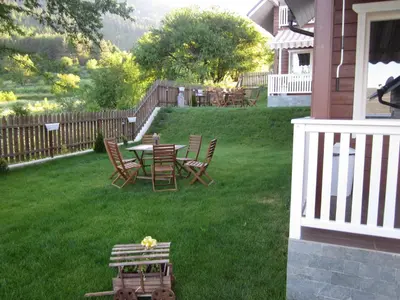 a yard with a table and chairs and a fence at Holiday Village Orlino in Sarnitsa