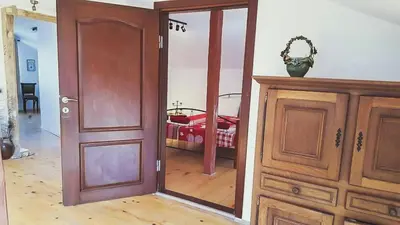an open wooden door in a room with a bedroom at The Old House guest rooms and apartament in Plovdiv