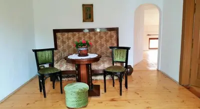 a table with four chairs and a vase on it at The Old House guest rooms and apartament in Plovdiv