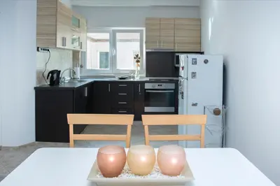a kitchen with a table and two chairs and a kitchen with a refrigerator at Cozy Apartment in the very centre of Sofia in Sofia