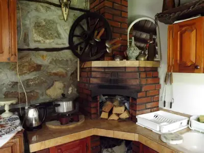 a kitchen with a brick fireplace and a stove at The Gates Apartments in Koprivshtitsa