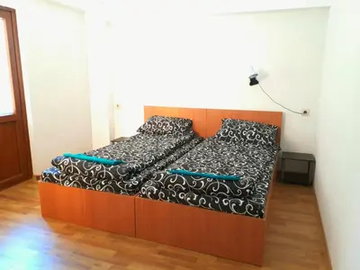 a bedroom with a bed with a black and white comforter at Къща Момина сълза in Sapareva Banya