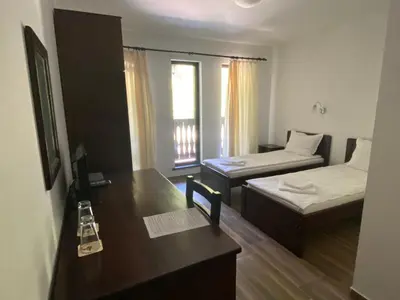 a small room with two beds and a desk with a desk at Complex Magic of the Rhodopes in Bachkovo