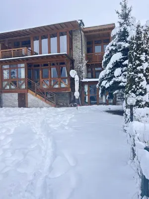 a snow covered yard in front of a building at Katarino Villa Nature Escape in Razlog