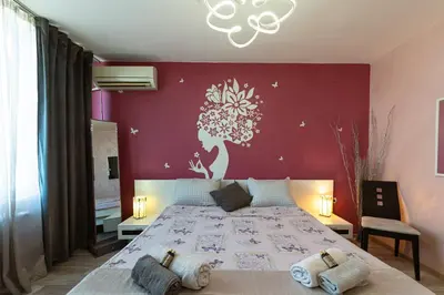 a bedroom with a large bed with a red wall at Apartments Rosina in Plovdiv