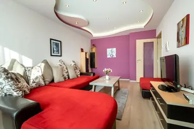 a living room with red furniture and purple walls at Apartments Rosina in Plovdiv