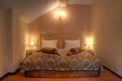 a bedroom with a bed with two dogs laying on it at Hotel Iva & Elena in Pamporovo