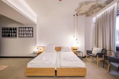 a bedroom with a large bed and a chair at R34 Boutique Hotel in Sofia