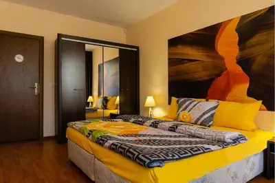 a bedroom with a bed and a painting on the wall at Vitosha Downtown Apartments in Sofia