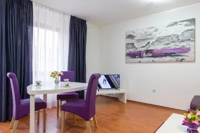 a dining room with a table and purple chairs at Vitosha Downtown Apartments in Sofia