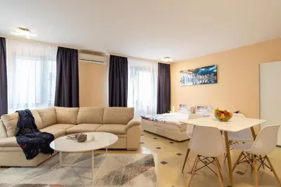 a living room with a couch and a bed and tables at Vitosha Downtown Apartments in Sofia