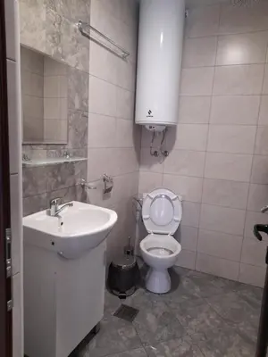 a white bathroom with a sink and a toilet at Guest Rooms IDeR in Sapareva Banya