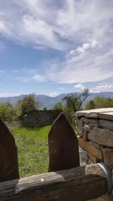 a stone fence with a view of the mountains at Скендерова Къща Къщичка Алиса in Leshten
