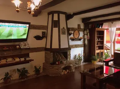 a living room with a television and a stone fireplace at Northstar Ski Apartment in Mountain Lake Hotel in Pamporovo