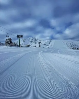 a snow covered ski slope with a ski lift at Къща за гости Плевнята in Bansko