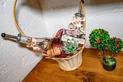 a basket with a wine bottle and a plant at Къща за гости Плевнята in Bansko