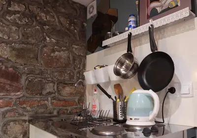 a kitchen with a stove with a pot and pans at Sofia Center Cave in Sofia