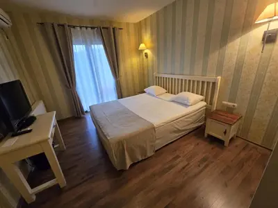 a hotel room with a bed and a television at Boutique Hotel Colosseo in Sandanski