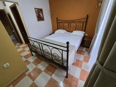 a bedroom with a black bed with white sheets and pillows at Boutique Hotel Colosseo in Sandanski