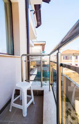 a white stool sitting on a balcony of a building at Flamingo Plovdiv in Plovdiv