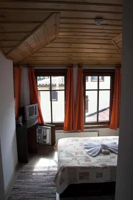 a bedroom with a bed and two windows at Hotel Old Times in Asenovgrad