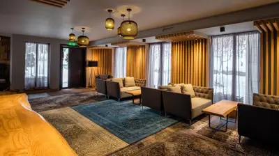 a hotel lobby with couches and tables and windows at Vila 6aTo Hotel & Wellnes in Sofia