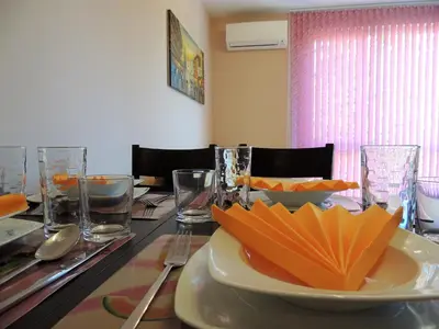 a table with a plate of orange napkins on it at Хисаря ВИП апартаменти in Hisarya