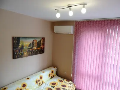 a bedroom with a pink curtain and a bed and a window at Хисаря ВИП апартаменти in Hisarya