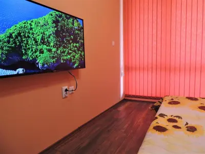 a room with a flat screen tv hanging on a wall at Хисаря ВИП апартаменти in Hisarya