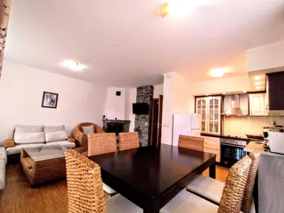 a kitchen and living room with a table and chairs at Вила Цветелина, Комплекс Александриa in Dobrinishte