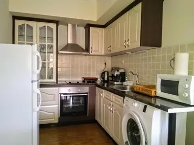a kitchen with a refrigerator and a washer and dryer at Вила Цветелина, Комплекс Александриa in Dobrinishte