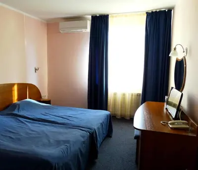 a hotel room with a bed and a desk and a window at Комплекс Белвю - Банкя in Bankya