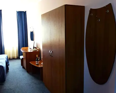 a hotel room with a bed and a wooden cabinet at Комплекс Белвю - Банкя in Bankya