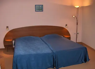 a bedroom with a bed with a blue blanket at Комплекс Белвю - Банкя in Bankya