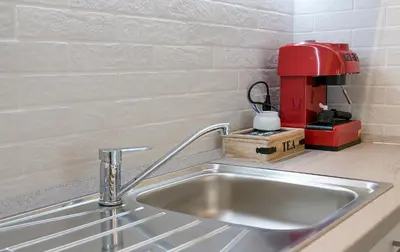 a kitchen counter with a sink and a red coffee maker at Shahbazian House in Plovdiv