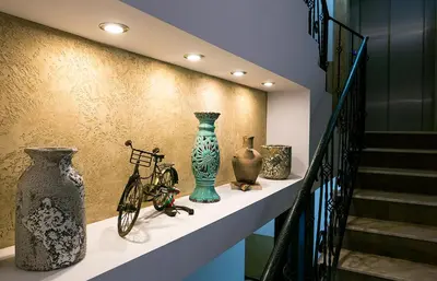 a display of vases on a shelf next to a staircase at Shahbazian House in Plovdiv