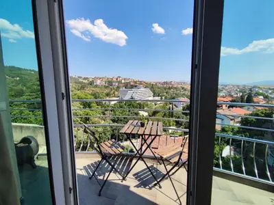 a balcony with two chairs and a view of the city at Hotel Avis in Sandanski
