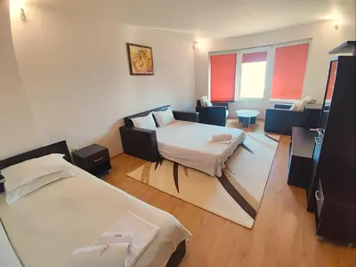 a hotel room with two beds and a couch at Hotel Avis in Sandanski