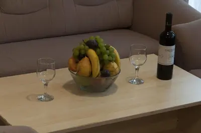 a bowl of fruit on a table with two wine glasses at Family Hotel Pautalia in Sandanski