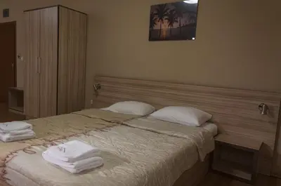 a bedroom with a bed with towels on it at Family Hotel Pautalia in Sandanski
