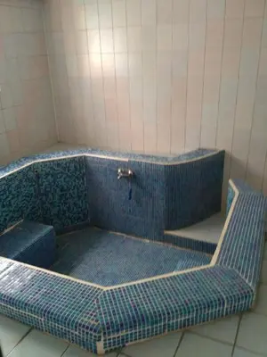 a blue tiled tub in a tiled bathroom at семеен хотел 