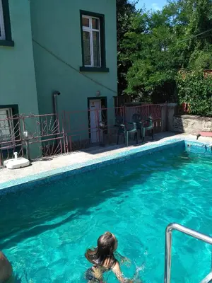 a woman in the water in a swimming pool at семеен хотел 