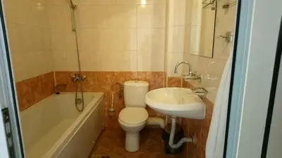 a bathroom with a toilet and a sink and a tub at семеен хотел 