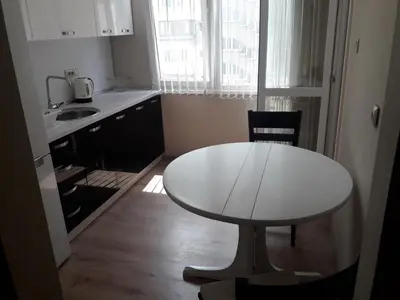 a small kitchen with a white table and a sink at Guest House Mania in Sofia